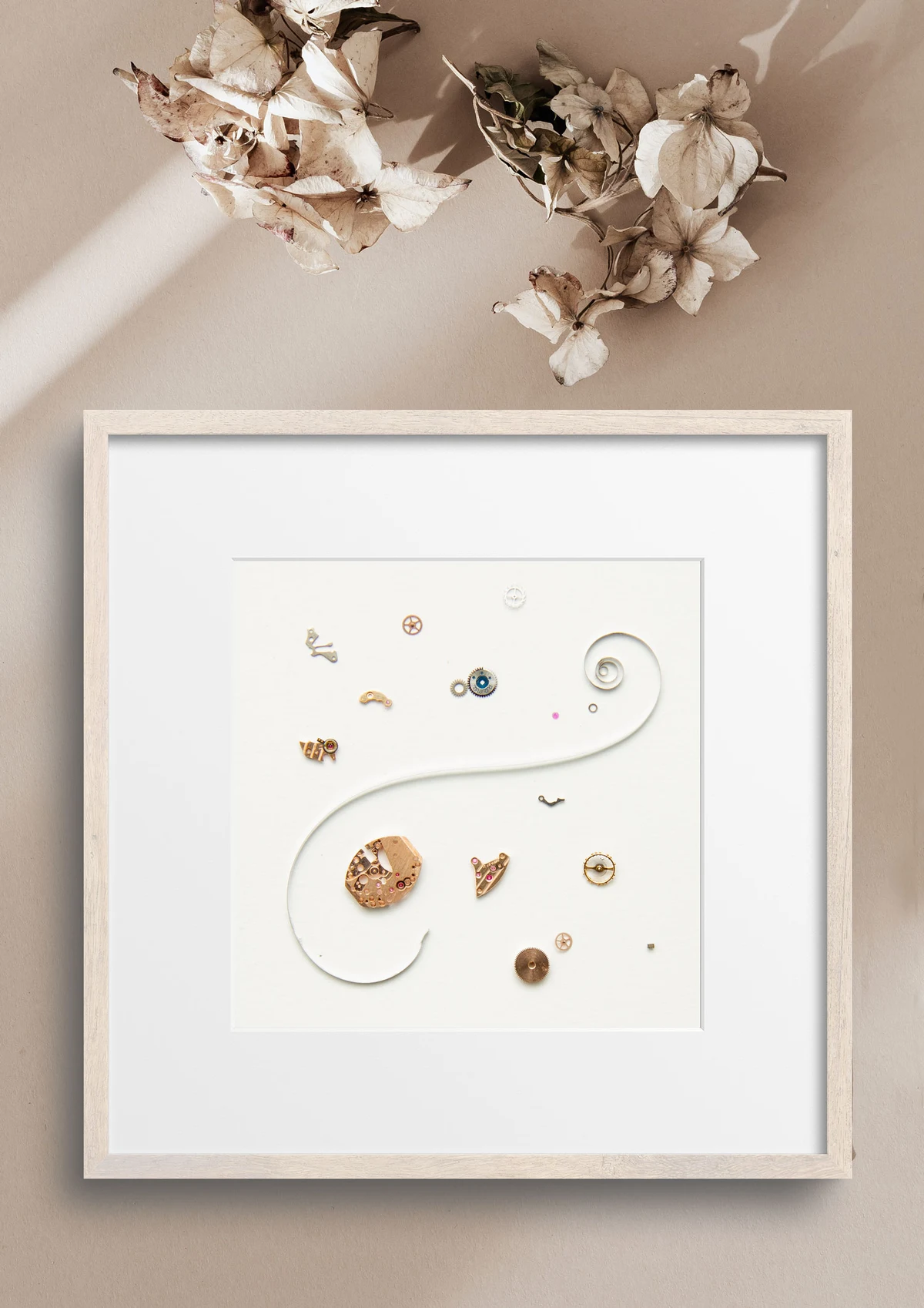 Gerahmtes Kunstwerk aus Uhrenteilen mit Blüten darüber